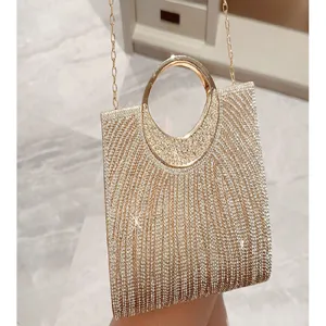 Dettaglio borsa da sera scintillante in strass, manico tondo in metallo e catena.