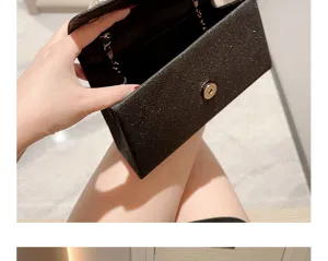 Pochette de soirée pailletée noire détail avec fermeture magnétique et chaîne.