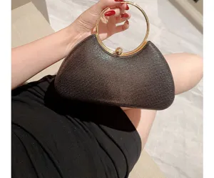 Élégante pochette de soirée noire avec poignée ronde en métal doré pour fêtes et mariages.