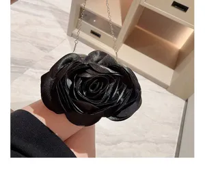 Nahaufnahme einer eleganten schwarzen Rosen Abendtasche mit zarter Metallkettenschulter.