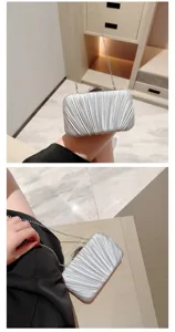 Silver pleated evening clutch bag with chain strap, elegant accessory for parties.