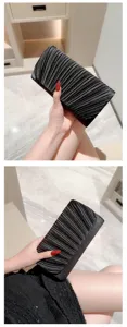 Detail view of a stylish black pleated clutch evening bag, elegant design for party use.