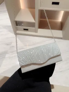 Sparkling silver evening clutch bag for women, elegant pleated party handbag with chain strap.