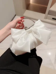 Elegante witte satinet avondhandtas met strik en metalen ringhandvat voor feestje.