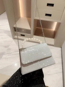 Sac de soirée strass argenté avec poignée perle et chaîne pour élégante robe de femme.