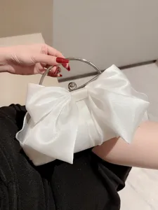 Elegante witte satijnen avondtas met grote strik en metalen handvat voor huwelijksfeesten.