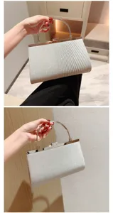 Silver glitter evening clutch bag with metal round handle and pleated design for women.
