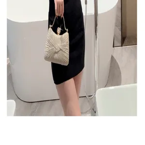 Glittering evening clutch bag featuring a stunning metallic handle and pearl clasp design.