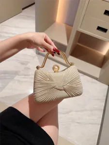 Elegant shimmering evening clutch bag with metallic handle and pearl clasp for parties.