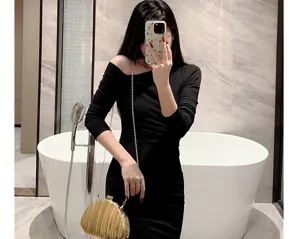 Detailed view of the shiny pleated evening chain bag in a stylish indoor setting.