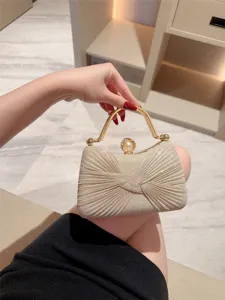 Elegant shimmering gold pleated evening clutch bag with metallic handle and pearl clasp.