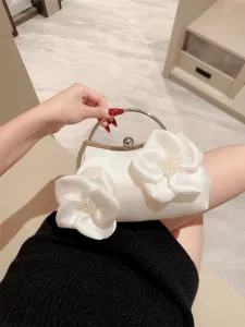 Elegant white satin evening clutch bag with 3D floral pearl decor and metal round handle.