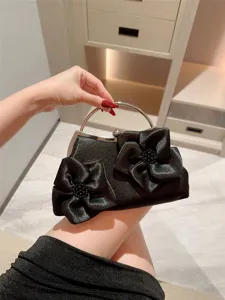 Elegant black satin evening bag with stunning floral design, perfect for weddings and parties.