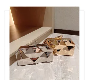 Geometric metallic evening clutch bag detail, showing unique faceted design and shiny surface.