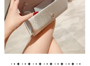 Clutch bag detail shot showing sparkling silver satin fabric, metal chain strap and clasp.