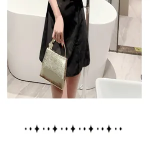 Detailed view of the elegant shiny gold leather evening bag featuring a chic metal ring handle.