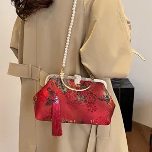 Chic Chinese style embroidered evening bag featuring pearl chain strap and red tassel detail.
