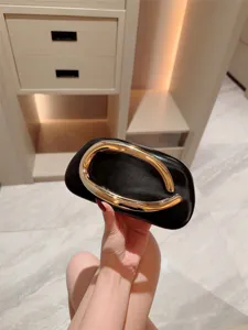 Luxury black evening clutch bag with oversized gold metallic handle for women party banquets.