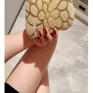 Close-up of vintage pearl evening clutch bag with elegant floral beadwork and gold accents.