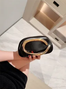 Luxury black clutch bag with unique gold metal handle design, perfect for evening parties.