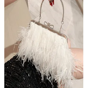 Detailed view of luxury white feather evening bag with metallic handle and clasp.