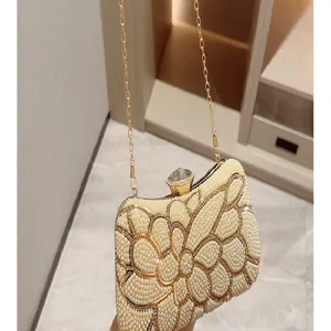 Elegant pearl evening clutch bag with sparkling rhinestone crystal clasp and gold chain strap.
