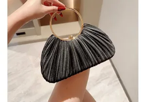 Detailed shot of a black pleated evening clutch bag with elegant golden round ring handle.