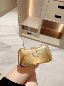 Elegant gold leather evening clutch bag with crystal teardrop clasp and chain strap for party.