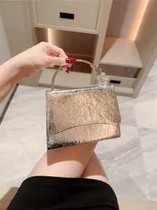 Gold metallic cracked leather evening bag with metal ring handle and crystal flower accent.