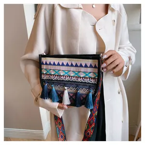 Ethnic style embroidered crossbody bag for women with tassels and colorful strap detail.
