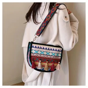 Boho ethnic embroidered crossbody bag with wide strap and tassels, detailed style view.