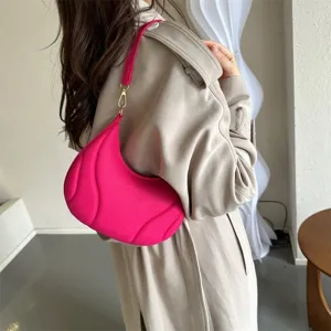 Detail shot of a trendy pink underarm shoulder bag showcasing unique textured design and hardware.