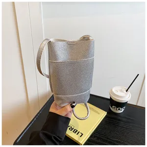 Silberne vertikale Handytasche für Damen, minimalistische Mini Umhängetasche, leicht und chic.