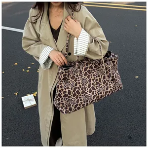 Detailed outdoor lifestyle shot of a stylish leopard print canvas tote bag, casual daily use.