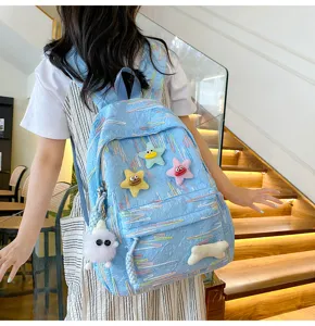 Detailed view of the cute blue backpack with plush star charms and soft fabric design.