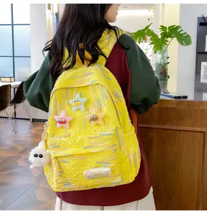 Cute yellow canvas backpack for teenage girls, sweet style bookbag with plush charms for travel.