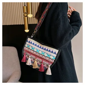 Boho ethnic style embroidered crossbody bag for women with colorful tassels and wide strap.