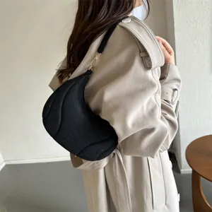 Detailed view of women black French style underarm shoulder bag with trendy pleated design.