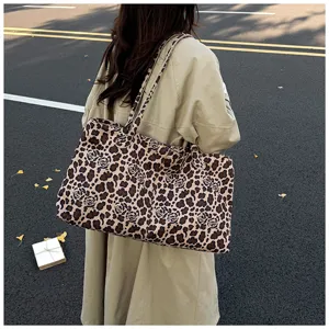 Detail shot of casual leopard print canvas tote bag, spacious design for daily commute use.