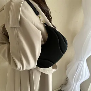 Detailed view of black minimalist crescent underarm shoulder bag showing elegant texture.
