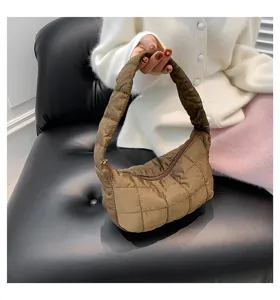 Detail view of the brown quilted puffer underarm bag showcasing soft cloud texture and zipper closure.