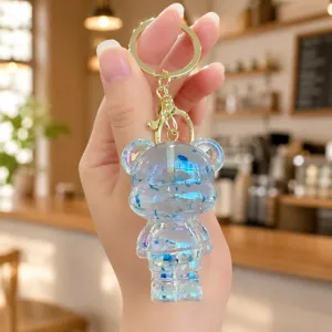 Transparent crystal glitter bear keychain close up, cute acrylic bag charm with gold ring.