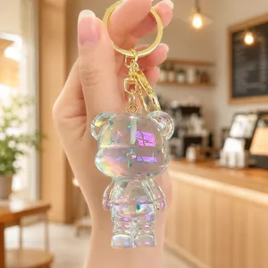 Close-up detail of the iridescent clear acrylic bear keychain pendant with gold ring.