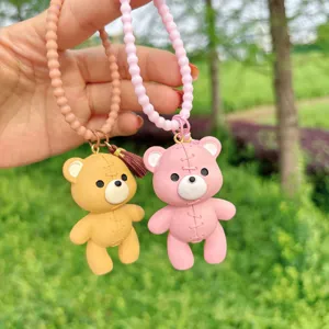 Detalle del llavero y colgante de bolso de oso de resina cosido de dibujos animados lindos.