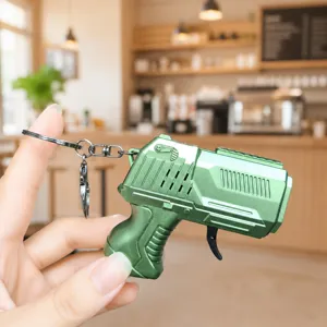 Mini metallic green toy gun keychain with flint sparks mechanism, creative decompression gift.
