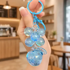 Close-up detail of blue crystal bubble apple keychain charm, showing transparent resin texture.