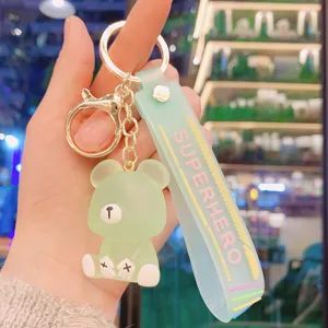 Close-up detail shot of the translucent green resin bear keychain with a fashion strap.