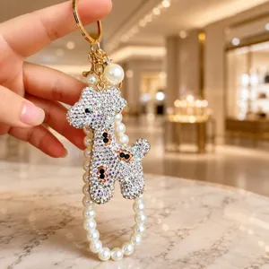 Rhombus rhinestone giraffe keychain detail view with pearl strap and metal hook pendant.