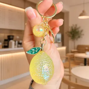Close-up detail of cute lemon keychain, jelly acrylic fruit bag charm with gold metal ring.