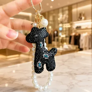 Exquisite black rhinestone giraffe keychain with pearl strap detail, perfect chic bag charm.
